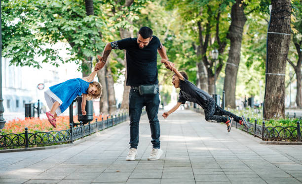istock Children having fun with dad in the park 890325448