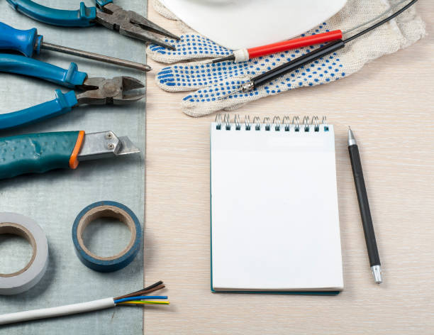istock .Set of electrical tools, white helmet and notepad on metallic background. Energy concept. 890353876