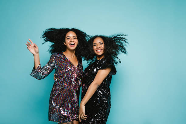 istock Female friends dancing back to back in studio against blue background 890358428