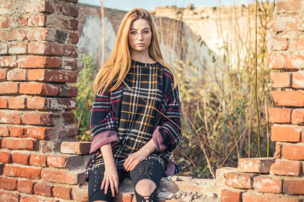 istock Beautiful blonde girl near old bricks wall. 890363878
