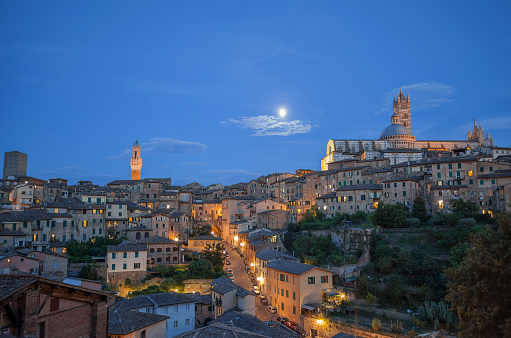 Twilight view over Sienna. With Siena Cathedral, The Siena tower and Illuminated windows.