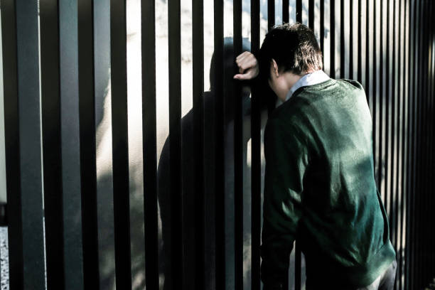 Bussinessman standing in front of a fence Bussinessman standing in front of a fence. insufficient funds stock pictures, royalty-free photos & images