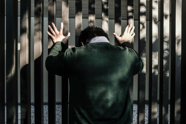 istock Bussinessman standing in front of a fence 890372518