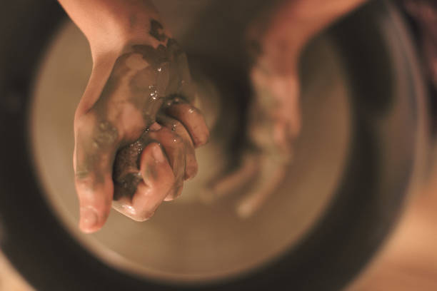 Pottery artist making a shape from clay. Shallow DOF. Developed from RAW; retouched with special care and attention; Small amount of grain added for best final impression. 16 bit Adobe RGB color profile.