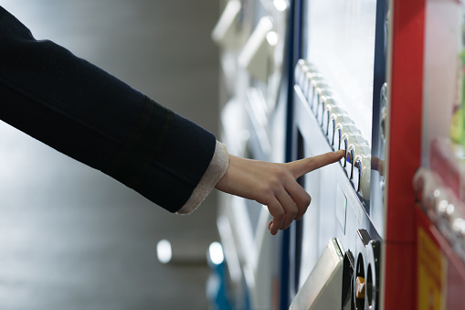 Woman buying with a vending machine.