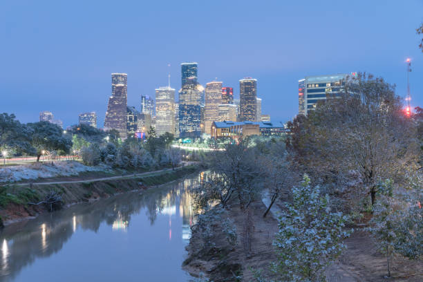 Snowfall along Bayou River bank and downtown Houston