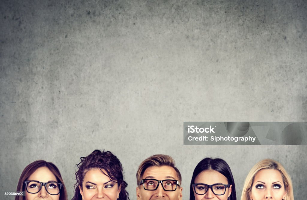 Acercamiento de los jóvenes jefes de pie cerca de una pared concreto gris. Un concepto de equipo y el intercambio de ideas de negocios diversos - Foto de stock de Contemplación libre de derechos