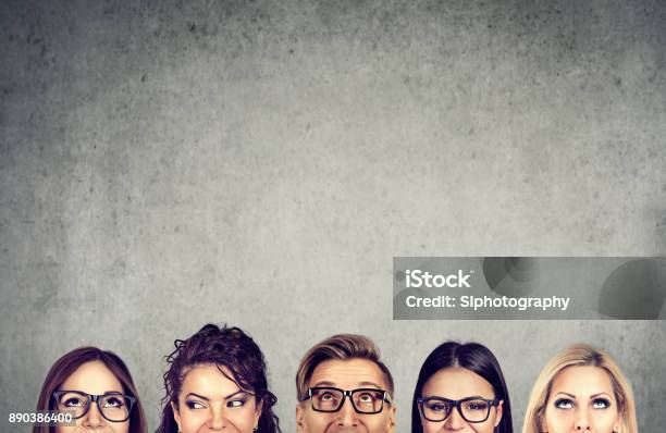 Closeup Of Young People Heads Standing Near A Gray Concrete Wall A Diverse Business Team And Brainstorming Concept Stock Photo - Download Image Now