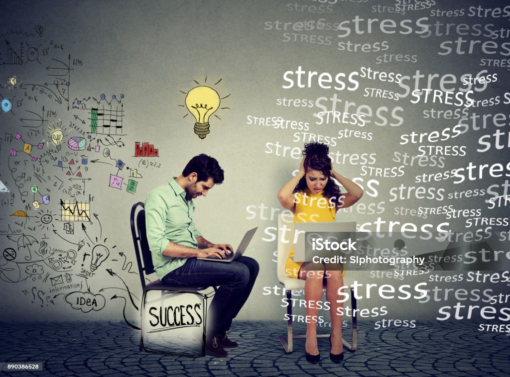 Successful man with clear strategy working on laptop computer next to a stressed young woman Emotional Stress Stock Photo
