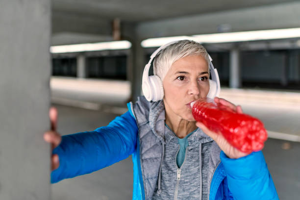 istock Woman drinking energy drink after jogging 890402488