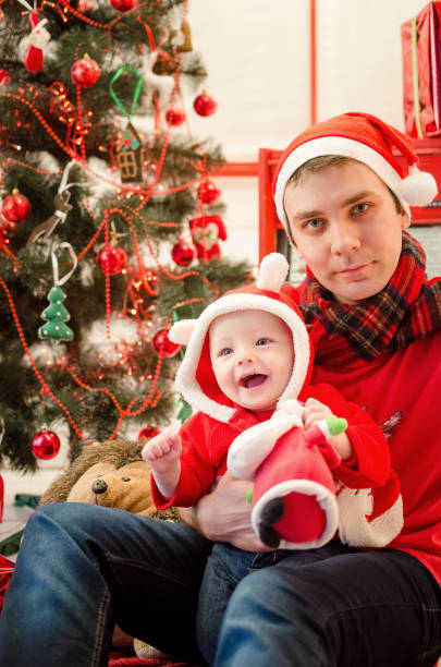 vater mit baby in der weihnachtszeit - christmas present men male people stock-fotos und bilder