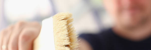 istock Arm of smiling worker hold brush closeup 890407902