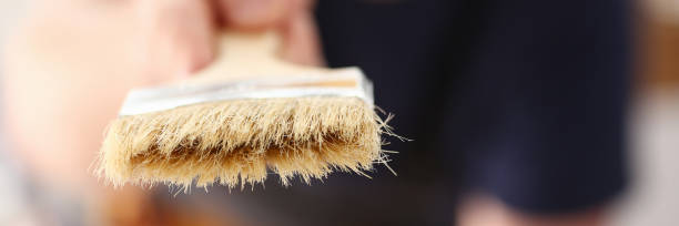 istock Arm of smiling worker hold brush closeup 890407972