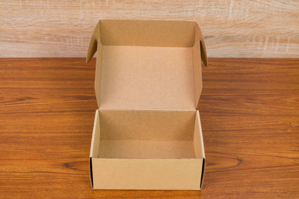istock Empty opened brown cardboard box or tray for mock up on the wooden table with copy space. 890408038