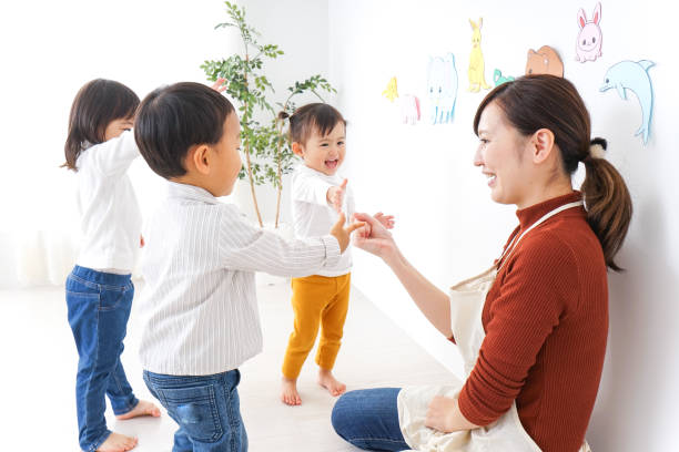 niños y maestro en el jardín de la infancia - family multi ethnic group asian ethnicity cheerful fotografías e imágenes de stock