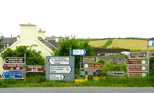 Array of street signs point every which way at an intersection in Ireland.