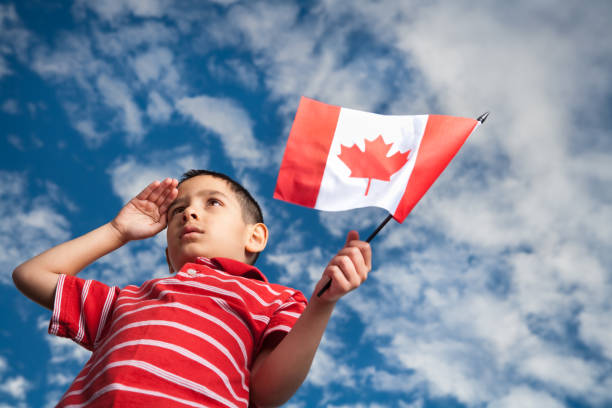 chłopiec świętuje dzień kanady - child patriotism saluting flag zdjęcia i obrazy z banku zdjęć