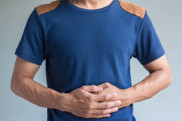 istock man have stomachache on gray background 890448744