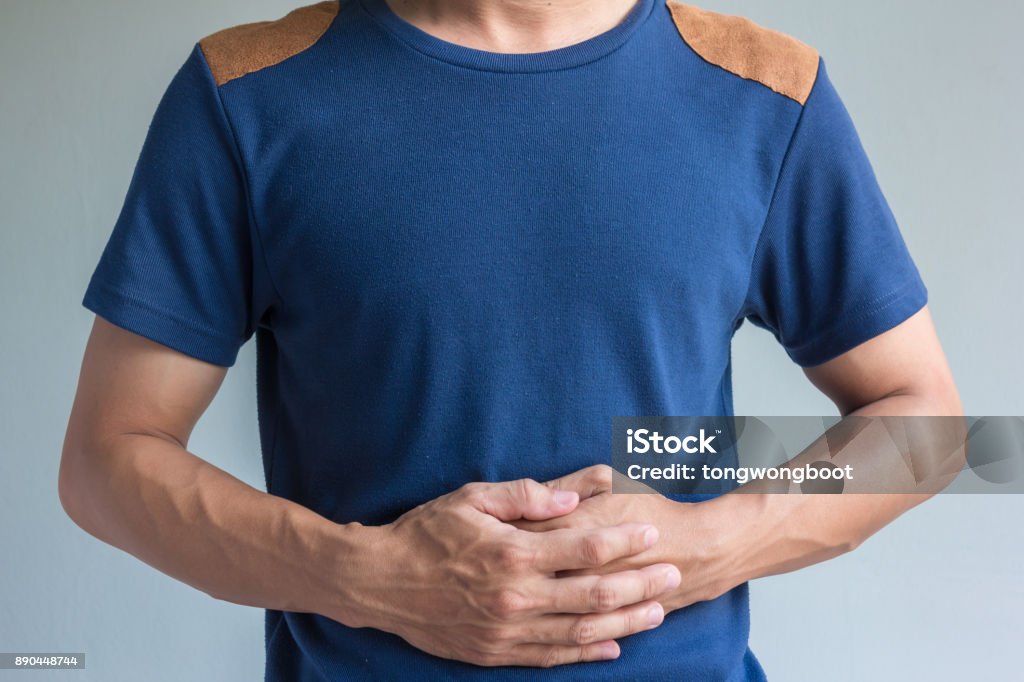 man have stomachache on gray background Gastroesophageal Reflux Disease Stock Photo