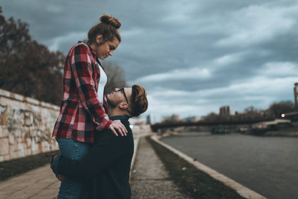 istock Beautiful young couple having fun near the river 890453874