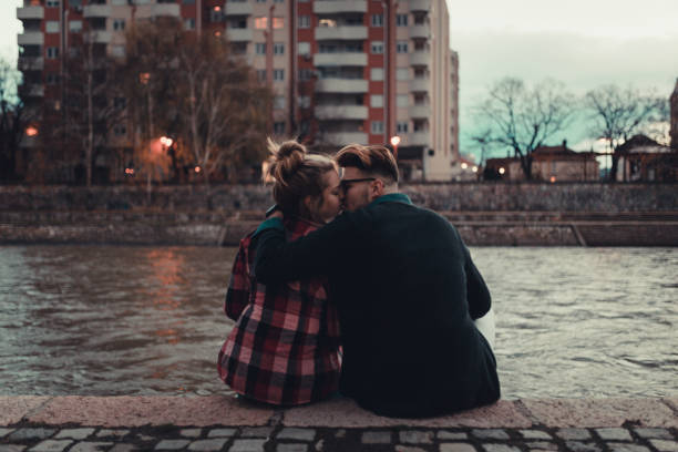 istock Cute young couple kissing on the river dock 890458914