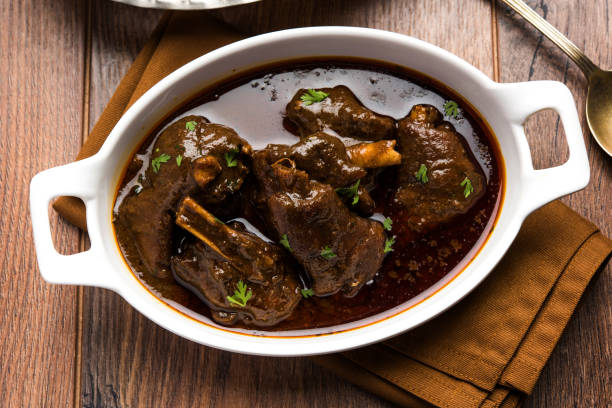 lamb shank or mutton or gosht paya or khoor curry served with indian bread or roti or naan - paya imagens e fotografias de stock