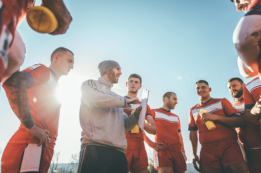 Coach talking to a group of rugby players during time out. Sports jersey are made specially for shooting purposes.