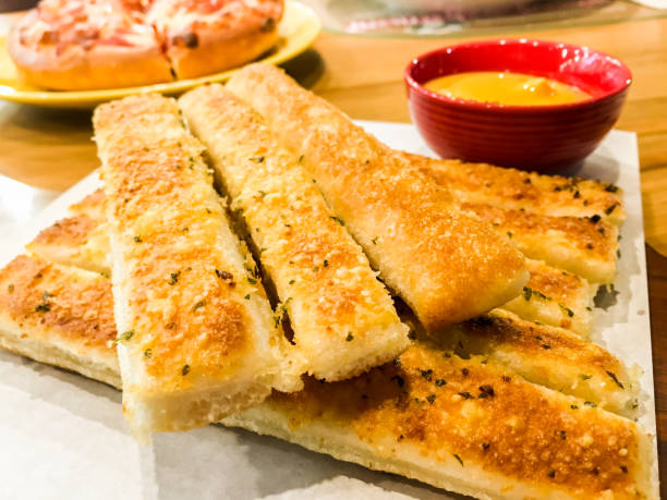 Homemade Cheesy Breadsticks Homemade Cheesy Breadsticks with Marinara Sauce for Dipping breadstick stock pictures, royalty-free photos & images