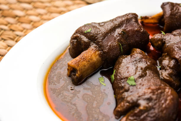 lamb shank or mutton or gosht paya or khoor curry served with indian bread or roti or naan - paya imagens e fotografias de stock
