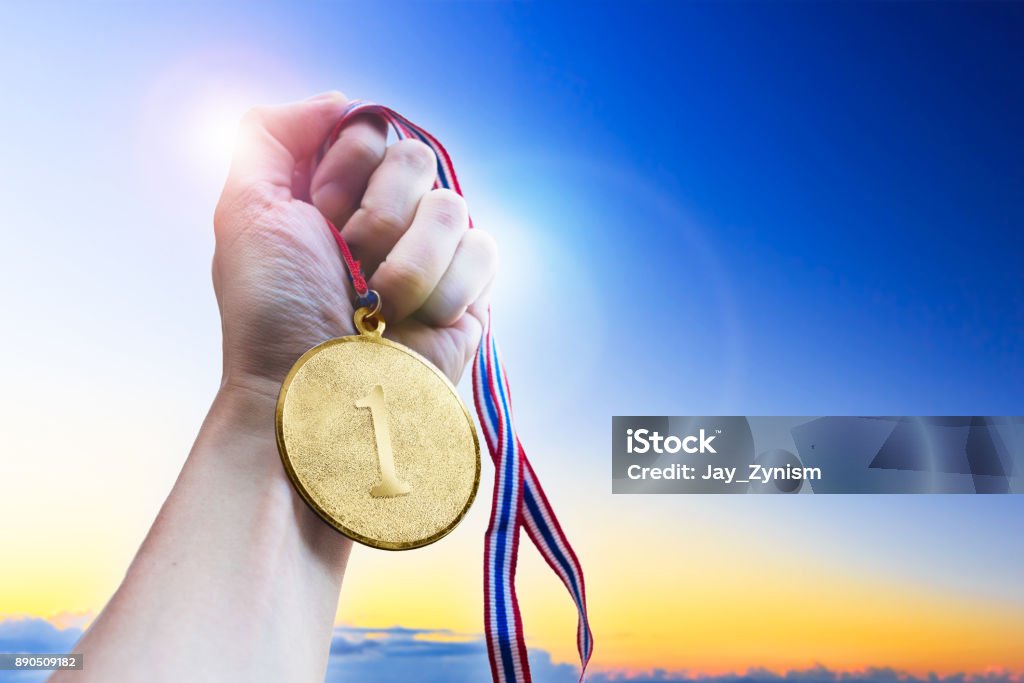 Businessman hand holding golden coin medal. Medal Stock Photo