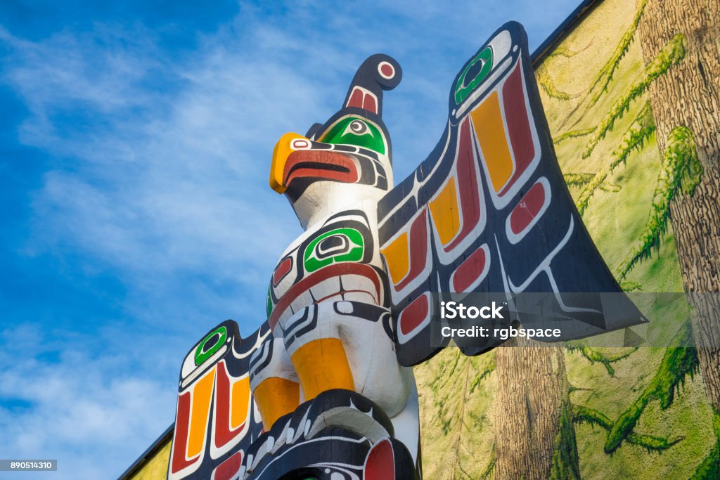 Ancient colorful Totem Pole in Duncan, British Columbia, Canada. View of ancient colorful Totem Pole with blue sky behind it in Duncan, British Columbia, Canada. Duncan - British Columbia Stock Photo