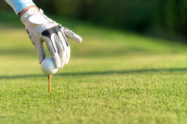 hand-asiatin aufstellen golfball auf tee mit club golfplatz an sonnigen tag für gesunden sport.  lifestyle-konzept - golf power golf course challenge stock-fotos und bilder