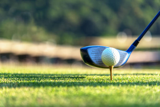 ゴルフ ・ ボール、ドライバー、グリーン ゴルフ スイング ティオフ夕日夜時間をやっているプレーヤーを閉じて、おそらく運動は。 健康とライフ スタイルのコンセプト。 - golf ball tee golf ball ストックフォトと画像