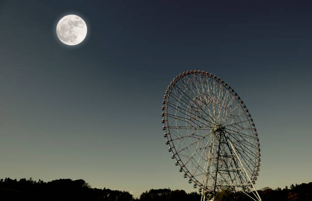 istock Full moon rising over the Ferris Wheel 890531828