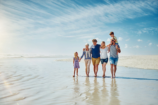 Shot of a happy family going for a walk together at the beach