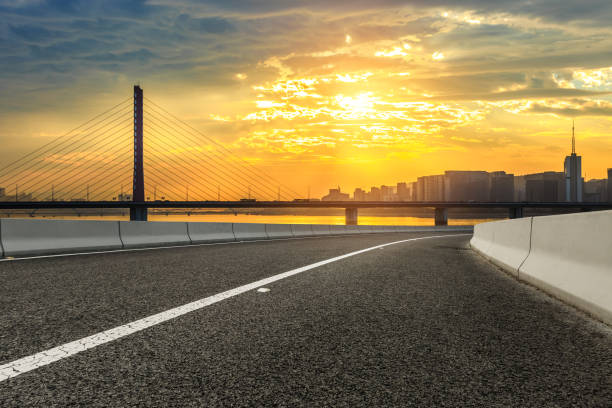 istock Empty asphalt road and city skyline at sunset 890561500