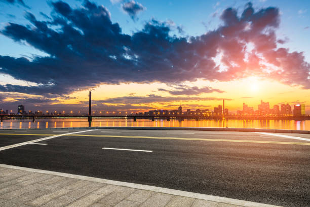 istock Empty asphalt road and city skyline at sunset 890561536