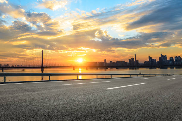 istock Empty asphalt road and city skyline at sunset 890561678