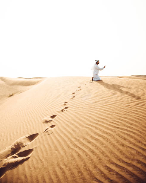 istock arabic man praying in the desert 890568728
