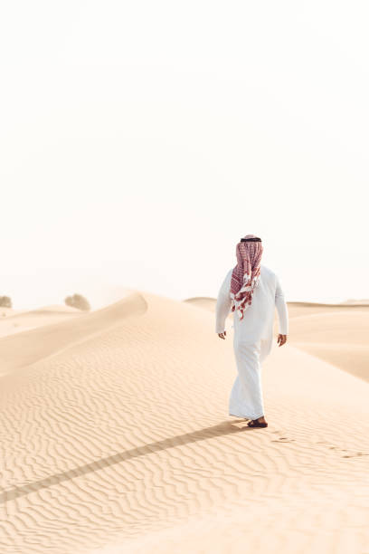 istock arabic man walking alone in the desert 890568742