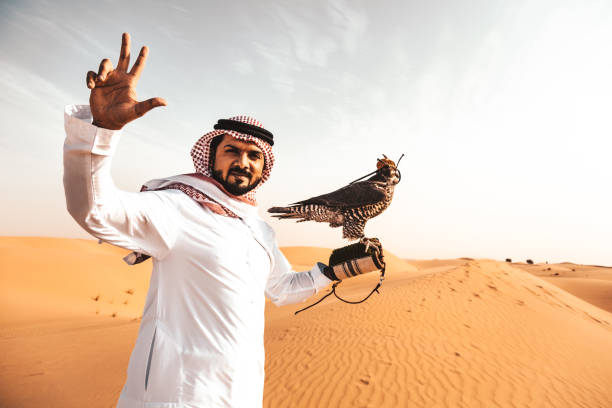 istock arabic man in the desert with a falcon 890570880