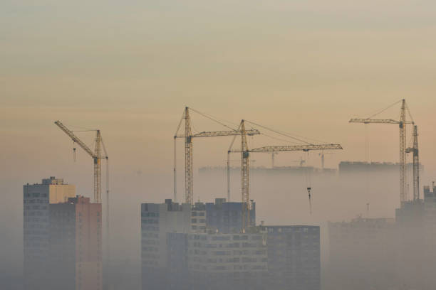 istock Crane and construction site in urban smog 890598014
