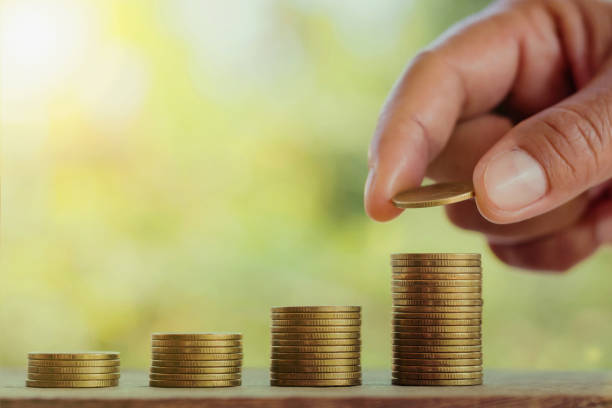 istock hand putting coins on stack for saving money business concept on table 890604320