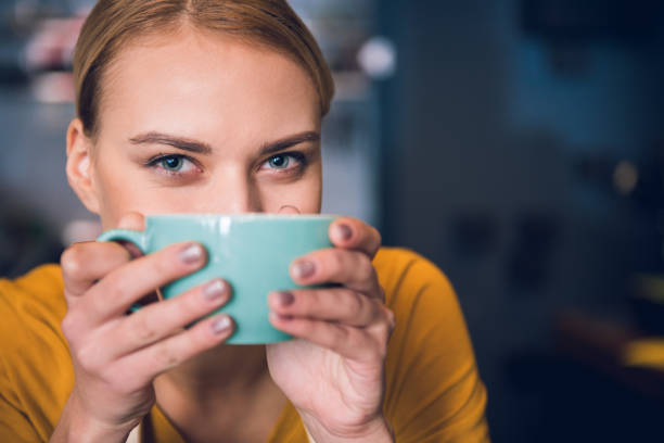 ragazza allegra che tiene la tazza vicino alla bocca - triteleia ixioides foto e immagini stock