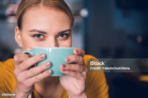 Cheerful Girl Keeping Mug Near Mouth Stock Photo - Download Image Now - Women, Drinking, Tea - Hot Drink