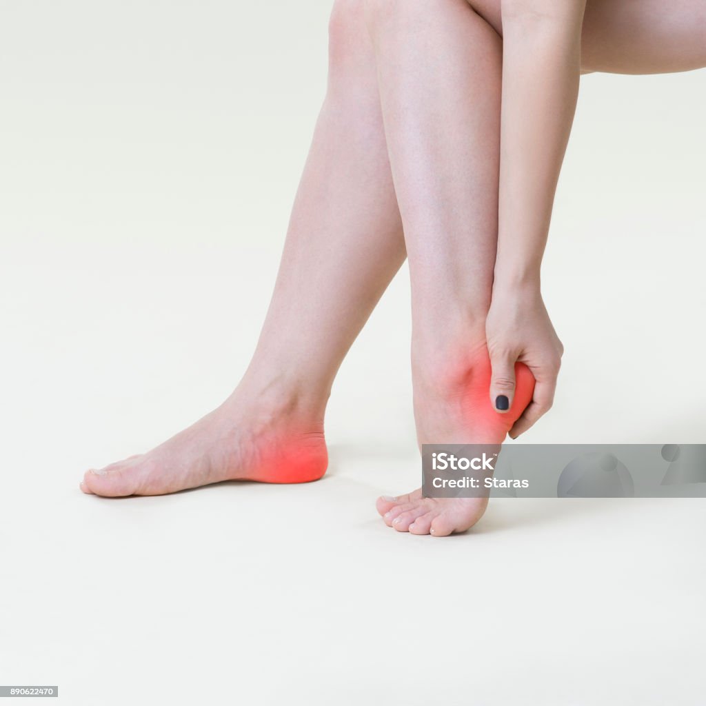 Dolor en las piernas de la mujer, masaje de pies mujer sobre fondo beige - Foto de stock de Dolor libre de derechos