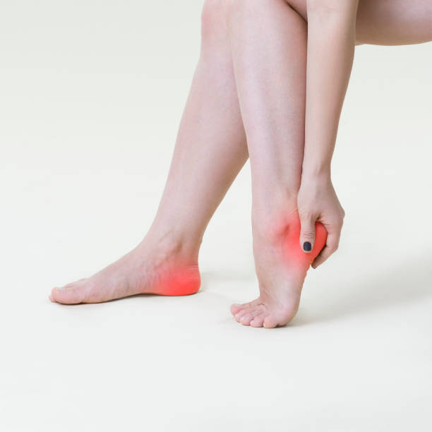 Pain in woman's legs, massage of female feet on beige background Pain in woman's legs, massage of female feet on beige background, studio shot clostridium tetani stock pictures, royalty-free photos & images