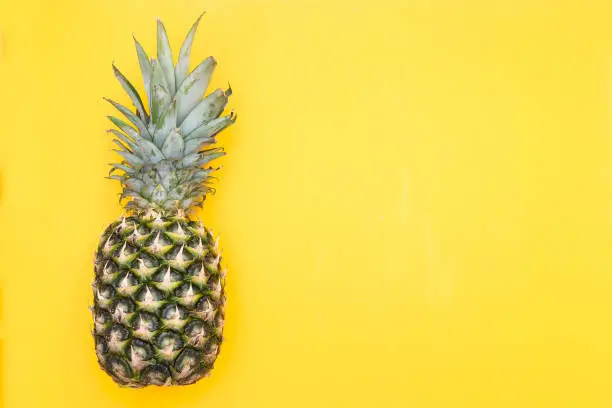 Photo of Fresh pineapple on a yellow background. Mock up