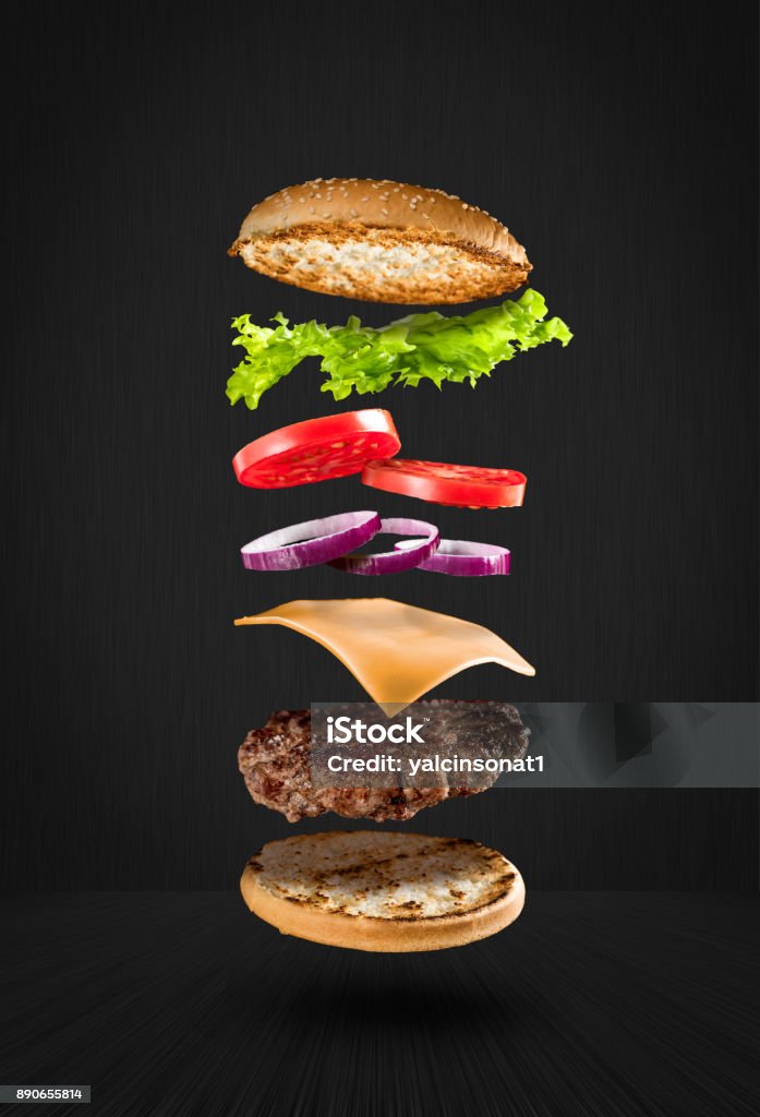 Delicious hamburger with flying ingredients on black background Burger Stock Photo