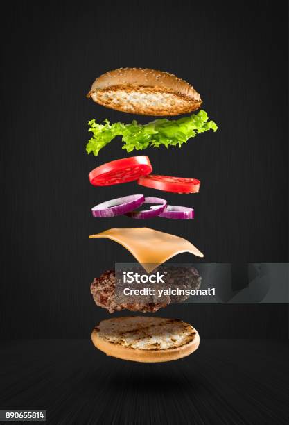 Delicious Hamburger With Flying Ingredients On Black Background Stock Photo - Download Image Now